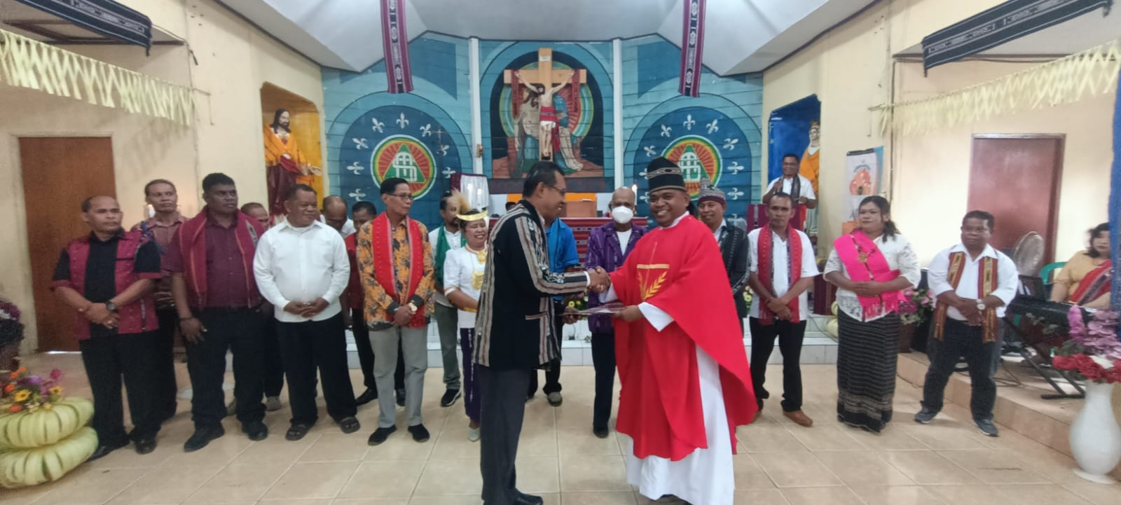 Ketua HKT Merauke, Theo Fatruan sedang menyerahkan bantuan dana senilai Rp30 juta kepada Pastor Paroki Santa Theresia Buti, Simon Petrus Matruty – Surya Papua/Frans Kobun