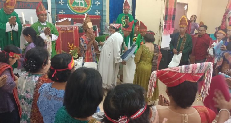 Sumbangan beras dan uang etnis Batak saat perayaan misa inkulturasi di Gereja Santa Theresia Buti – Surya Papua/Frans Kobun