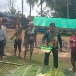 Pastor Paroki Santa Theresia Buti, Simon Petrus Matruty sedang memegang sagu sep yang siap dibakar-Surya Papua/Frans Kobun