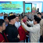 Presiden RI, Prabowo Subianto sedang memperbaiki baret Ketua PP PMKRI, Susana Kandaimu – Surya Papua/IST