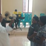 Pastor Simon Petrus Matruty sedang memerciki Nathalia dengan air berkat – Surya Papua/Frans Kobun