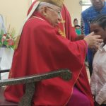 Uskup Mandagi sedang mengurapi krismawan-krismawati yang menerima sakramen krisma di Gereja Santa Theresia Buti – Surya Papua/Frans Kobun