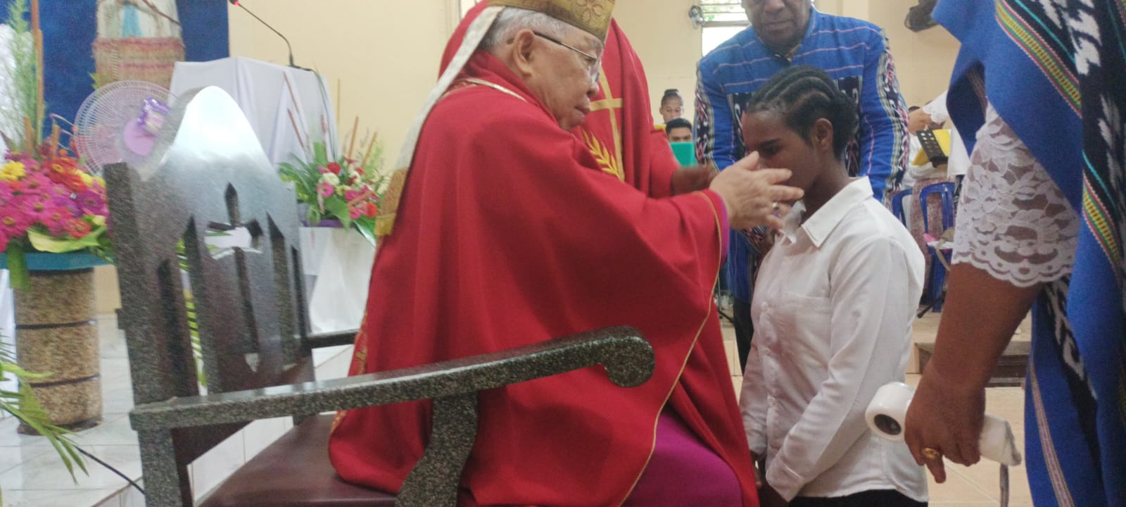 Uskup Mandagi sedang mengurapi krismawan-krismawati yang menerima sakramen krisma di Gereja Santa Theresia Buti – Surya Papua/Frans Kobun