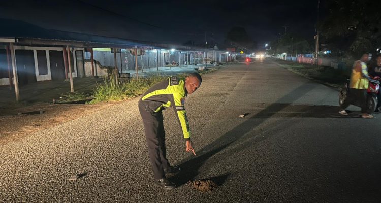 Salah seorang anggota polisi sedang menunjuk lokasi atau tempat korban ditabrak – Surya Papua/IST