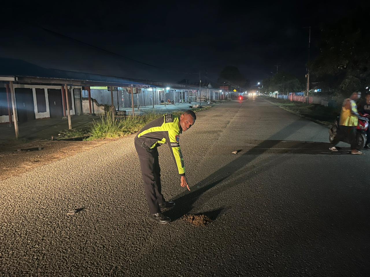 Salah seorang anggota polisi sedang menunjuk lokasi atau tempat korban ditabrak – Surya Papua/IST