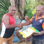 Penyerahan beras secara simbolis oleh Romanus Mbaraka kepada Kepala Kampung Kweel – Surya Papua/Frans Kobun