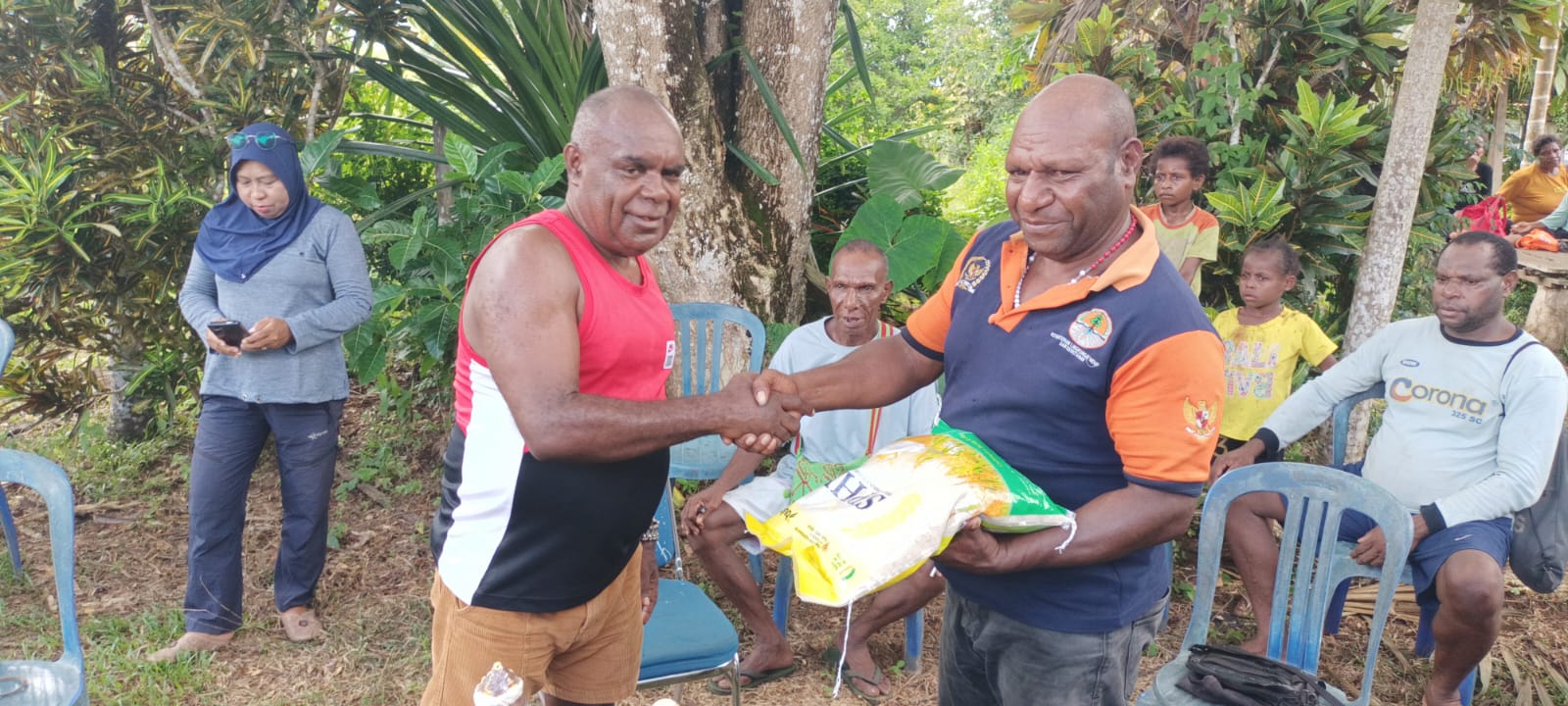 Penyerahan beras secara simbolis oleh Romanus Mbaraka kepada Kepala Kampung Kweel – Surya Papua/Frans Kobun