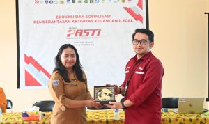 Pemberian plakat dalam sosialisasi yang dilakukan OJK di Kelurahan Muli – Surya Papua/IST