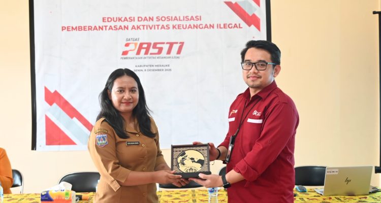 Pemberian plakat dalam sosialisasi yang dilakukan OJK di Kelurahan Muli – Surya Papua/IST