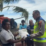 Kapolres Merauke, Leonardo Yoga sedang menyerahkan bantuan beras kepada warga yang terdampak banjir rob – Surya Papua/IST