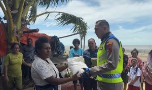 Kapolres Merauke, Leonardo Yoga sedang menyerahkan bantuan beras kepada warga yang terdampak banjir rob – Surya Papua/IST