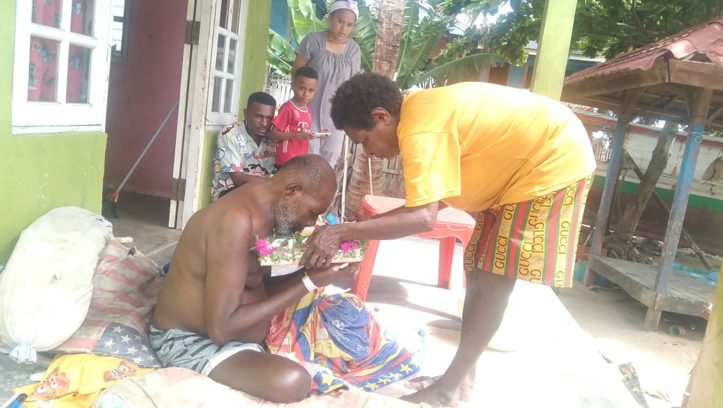 Salah seorang bapak sedang mencium Kanak-Kanak Yesus saat diarak di rumahnya – Surya Papua/IST