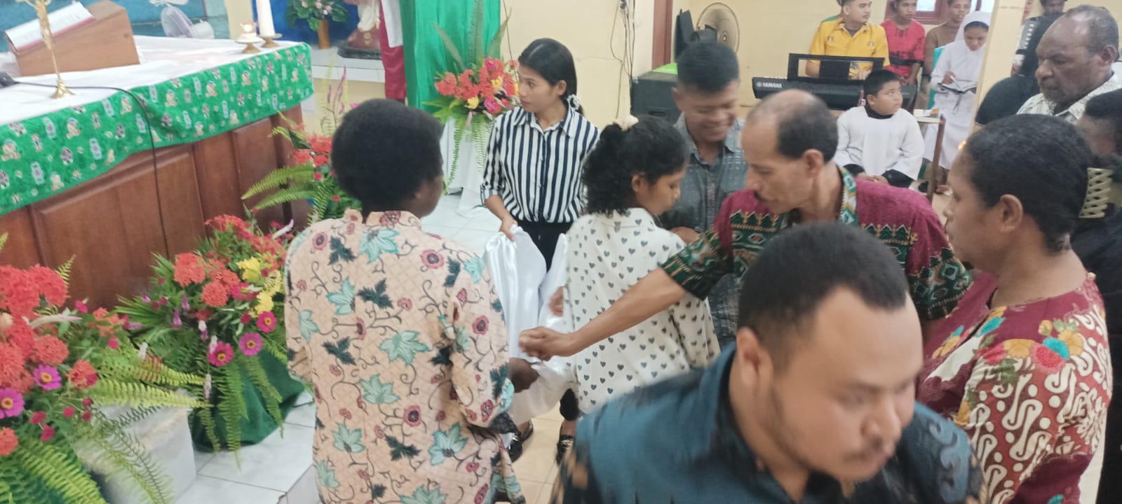 Umat sedang memberikan seadanya yang dimiliki untuk Pastor Yakobus Zakaria Balia – Surya Papua/Frans Kobun