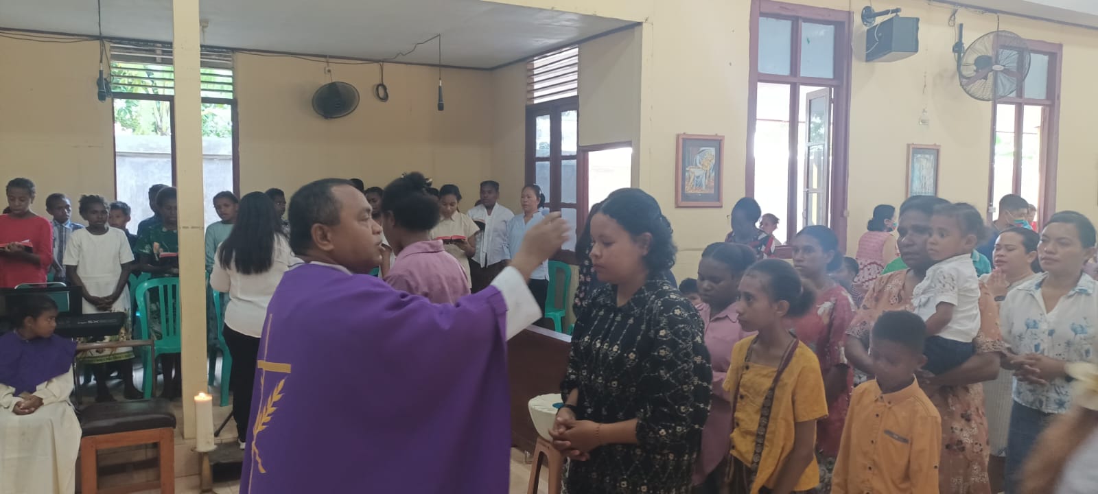Pastor Simon Petrus Matruty sedang menandai abu di dahi umat – Surya Papua/Frans Kobun