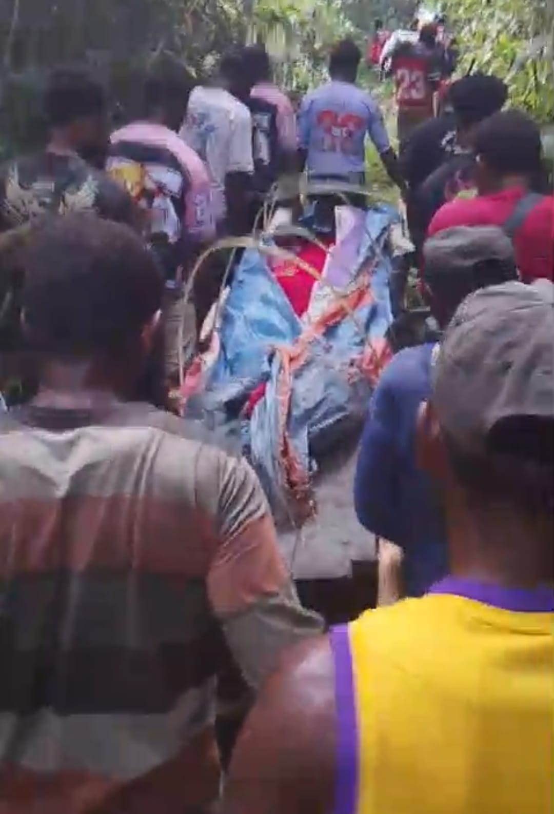 Puluhan masyarakat di pedalaman Kabupaten Merauke sedang memikul jenazah melalui hutan – Surya Papua/IST