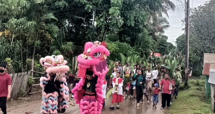 Perarakan umat pada perayaan Minggu Palma di Gereja Santa Theresia Buti – Surya Papua/Frans Kobun