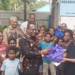 Bupati Merauke, Yoseph Bladib Gebze menyerahkan secara simbolis bantuan kepada Pastor Paroki Santa Theresia Buti, Simon Petrus Matruty – Surya Papua/Frans Kobun