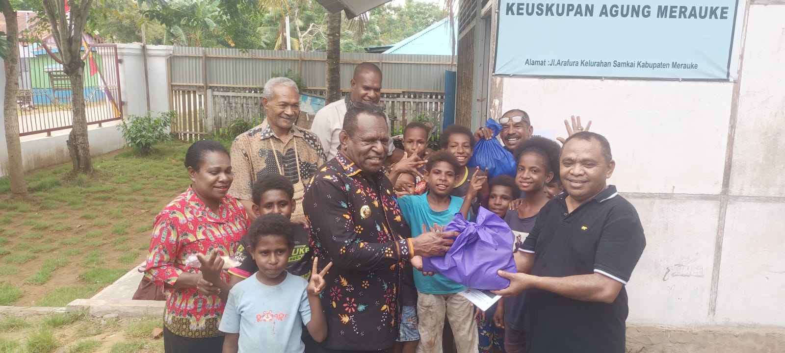 Bupati Merauke, Yoseph Bladib Gebze menyerahkan secara simbolis bantuan kepada Pastor Paroki Santa Theresia Buti, Simon Petrus Matruty – Surya Papua/Frans Kobun