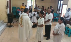 Pastor Simon Petrus Matruty sedang bersalaman dengan Yuliana di depan altar – Surya Papua/Frans Kobun