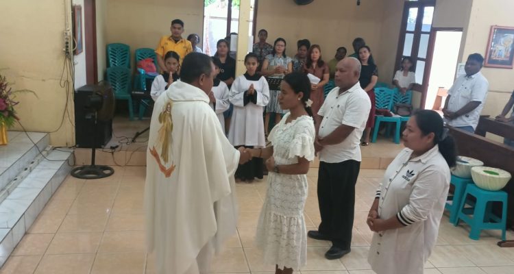 Pastor Simon Petrus Matruty sedang bersalaman dengan Yuliana di depan altar – Surya Papua/Frans Kobun