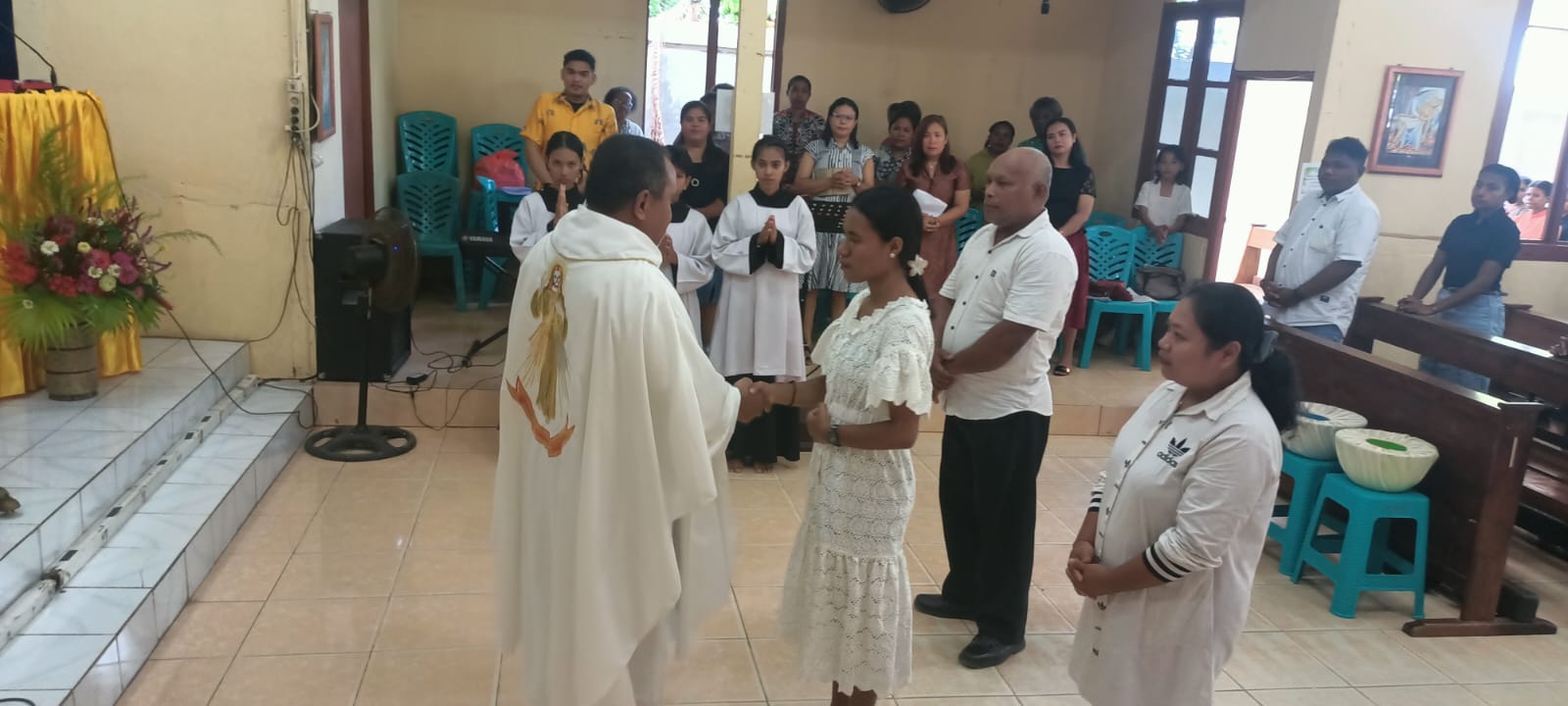 Pastor Simon Petrus Matruty sedang bersalaman dengan Yuliana di depan altar – Surya Papua/Frans Kobun