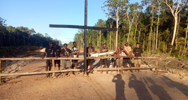 Salib yang ditancapkan di tengah jalan sebagai bentuk penolakan proyek jalan sepanjang 135 kilometer – Surya Papua/IST