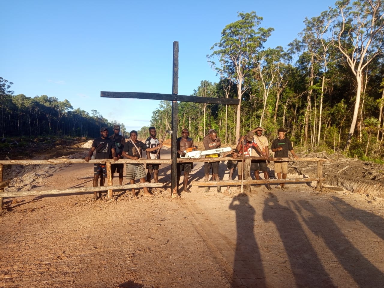 Salib yang ditancapkan di tengah jalan sebagai bentuk penolakan proyek jalan sepanjang 135 kilometer – Surya Papua/IST