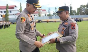 penghargaan tiga Kapolres Merauke, AKBP Leonardo Yoga serahkan piagam penghargaan kepada Kasi Humas Polres setempat, Ipda Andre MSB – Surya Papua/IST