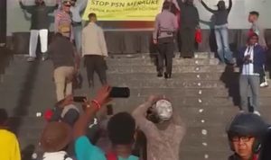 aksian -- Sejumlah aktivis dan mahasiswa yang membentangkan sehelai kain bertuliskan tolak PSN di Merauke – Surya Papua/IST