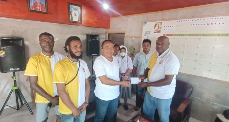 Penyerahan bantuan dana oleh Ketua Pemuda Buti Bangkit, Leonardus Ndiken kepada Pastor Simon Petrus Matruty – Surya Papua/Frans Kobun