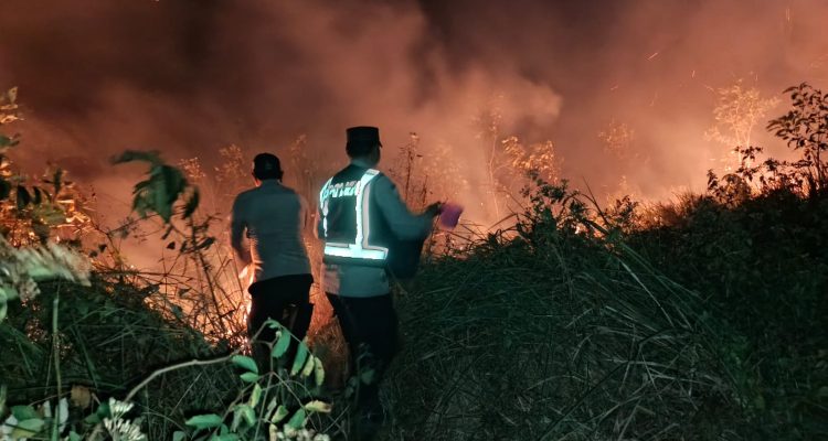 Aparat kepolisian bersama petugas damkar sedang berusaha melakukan pemadaman lahan yang terbakar – Surya Papua/IST