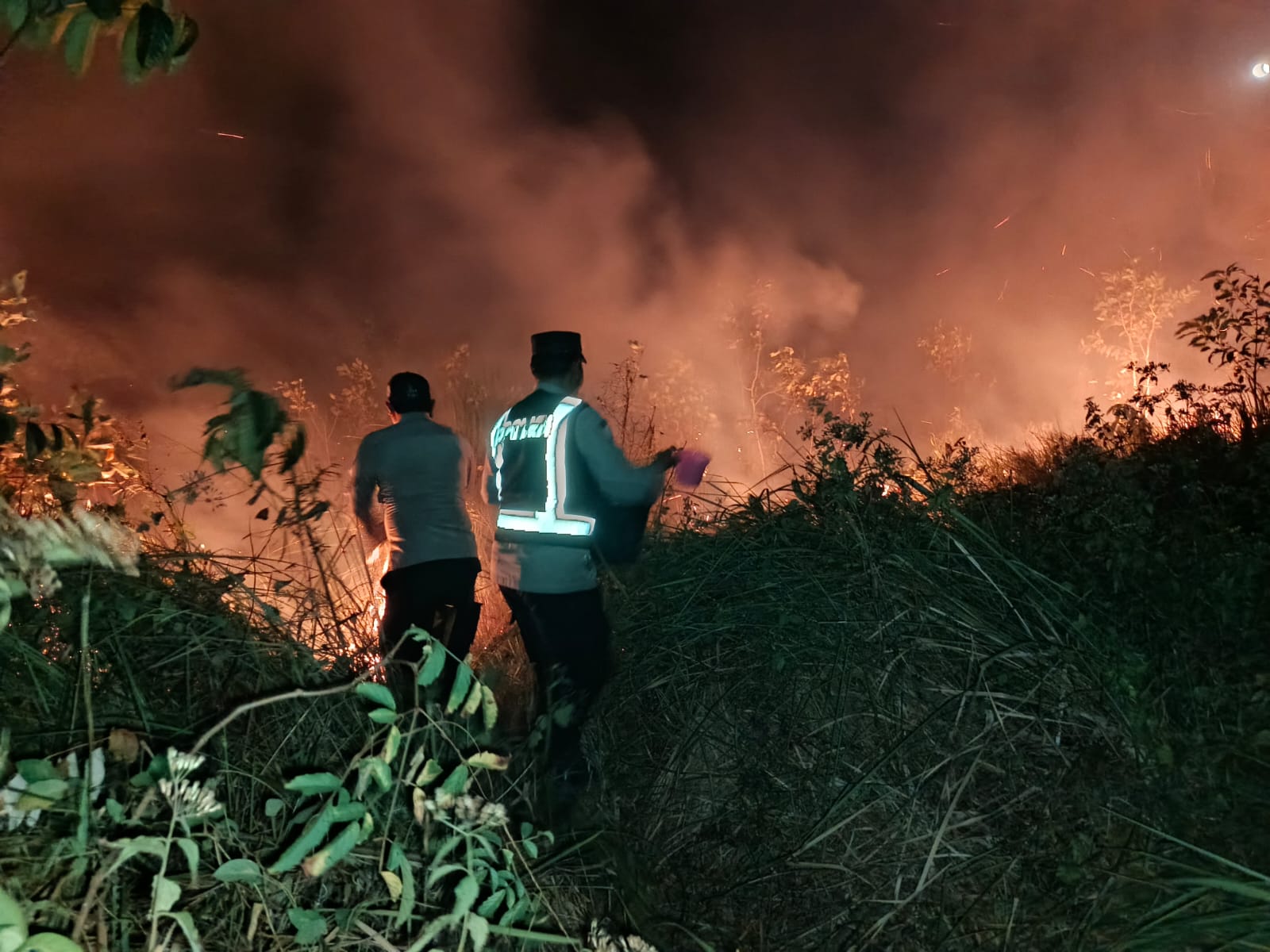 Aparat kepolisian bersama petugas damkar sedang berusaha melakukan pemadaman lahan yang terbakar – Surya Papua/IST
