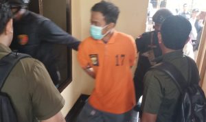 Tersangka pembunuhan korban yang digiring usai Kapolres Merauke memberikan keterangan pers – Surya Papua/Frans Kobun