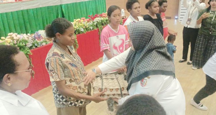 Wakil Bupati Merauke, Fauzun Nihayah sedang menyerahkan telur ayam kepada salah seorang warga yang merupakan bantuan dari Bank Papua – Surya Papua/Frans Kobun