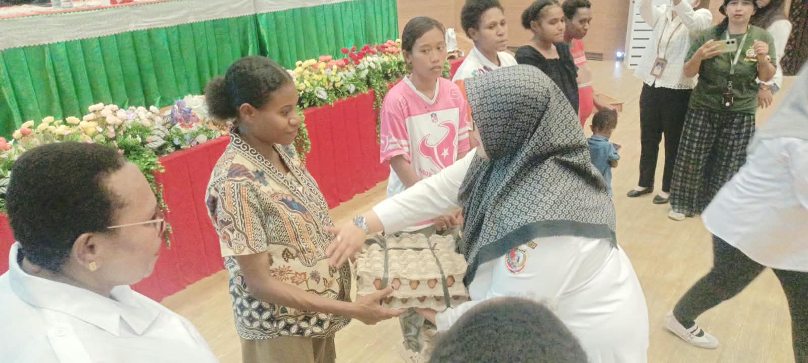 Wakil Bupati Merauke, Fauzun Nihayah sedang menyerahkan telur ayam kepada salah seorang warga yang merupakan bantuan dari Bank Papua – Surya Papua/Frans Kobun