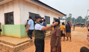 Salah seorang warga sedang dikenakan masker di Kampung Asiki, Distrik Jair, Kabupaten Boven Digoel – Surya Papua/IST