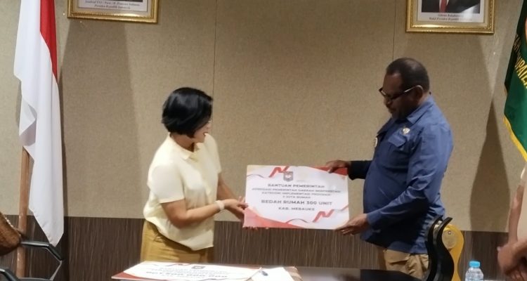 Penyerahan plakat oleh Asisten II Setda Merauke, Martha Bayu kepada Bupati Merauke, Yoseph Bladib Gebze – Surya Papua/Frans Kobun